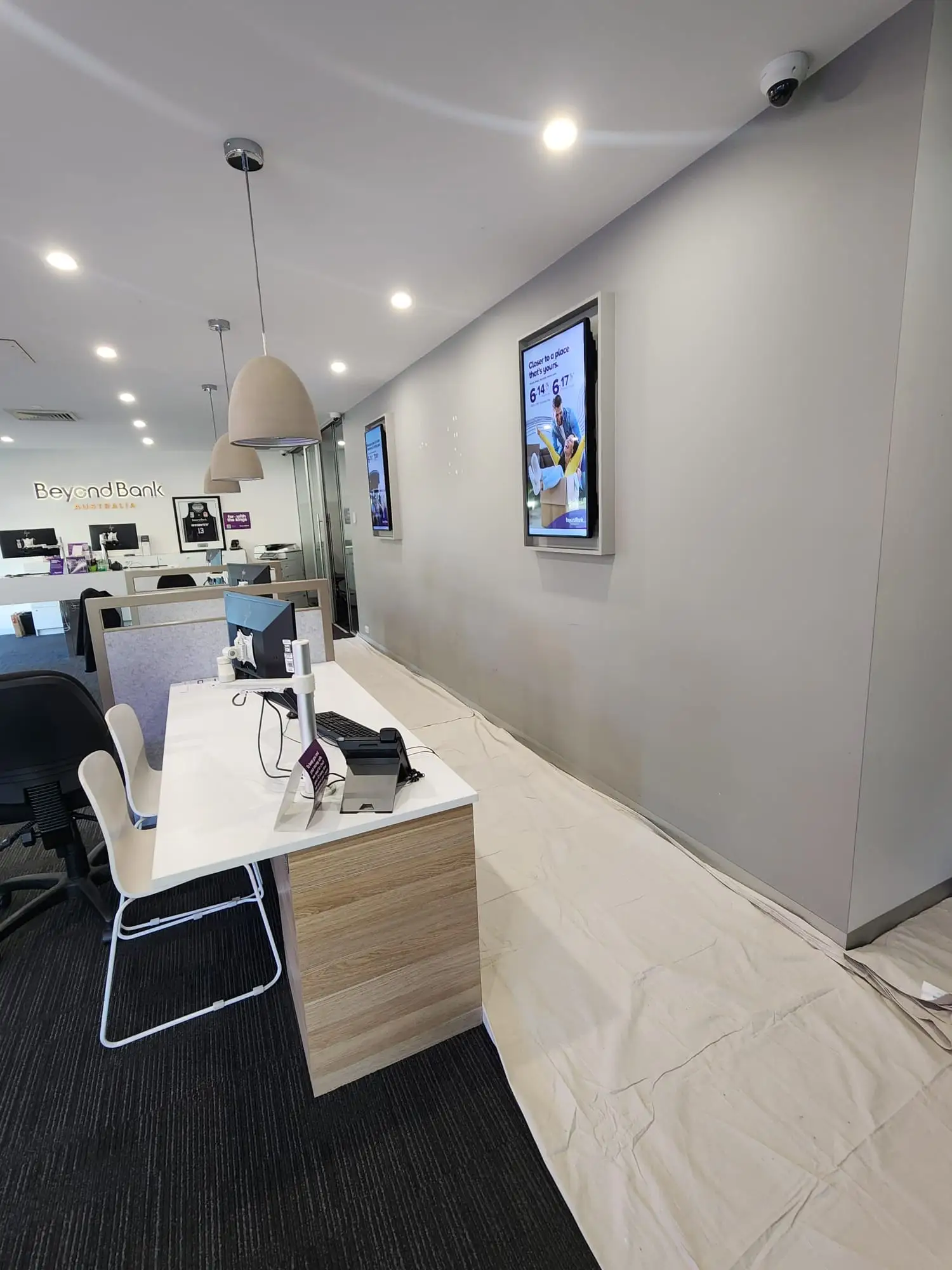 Commercial office wall prepared with drop sheets while the branch stays open