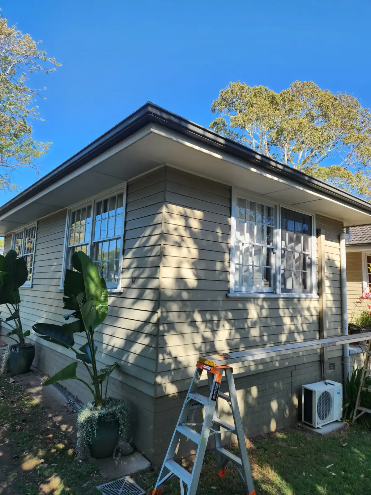 Finished exterior repaint showing fresh grey weatherboard coating in Newcastle