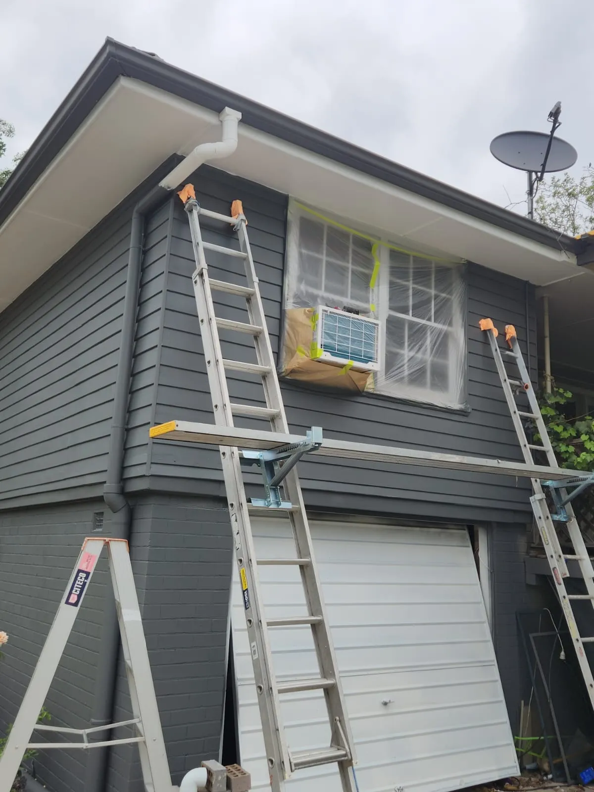 Ladders and planks set up against a Newcastle home during an exterior repaint
